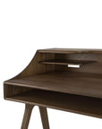 The Ethnicraft Flow Desk features angled legs, a raised back shelf, and an open cubby beneath the main desktop. Its dark, smooth wood finish makes it a stylish choice for any modern workspace.