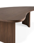 The Ethnicraft Boomerang Coffee Table in varnished teak features an organic, uniquely shaped top and vertical slatted legs, showcased against a white background.