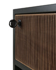 Close-up of a solid teak cabinet from Ethnicraft’s Oscar Drawer Unit, featuring vertical wood grooves and a black lock with a key inserted into the upper left corner of the cabinet door—an elegant office storage solution.