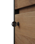A metal key marked “SOS” is inserted into the lock of the Ethnicraft Oscar Drawer Unit - Teak - Black, showcasing its horizontal wood grain and solid teak craftsmanship.