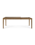 The Ethnicraft Bok Extendable Dining Table in Natural Teak features a minimalist design with straight legs and a slightly elevated right section, offering built-in compartments and accessories, crafted from solid teak wood.