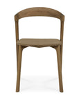 Front view of Ethnicrafts Bok Dining Chair - Natural Teak, showcasing a curved backrest, angled legs, and a minimalist design. Made from FSC-certified solid teak with a natural finish and subtly contoured seat.