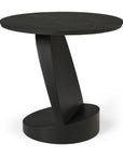 The Oblic Side Table - Black by Ethnicraft is a modern, sleek side table with a round top, slanted central support, and oval base—perfect for those who love sculptural, minimalist design in contemporary spaces.