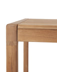 Close-up of the Ethnicraft Jack Outdoor Dining Table - Teak, featuring a minimalist design. Made from solid teak, it highlights the natural grain and smooth finish of light wood on both tabletop and legs.
