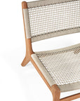 A close-up of the Ethnicraft Jack Woven Outdoor Lounge Chair highlights its contemporary wooden frame and refined light beige weave, set against a white background.