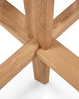 Close-up of the Circle Outdoor Dining Table - Natural Teak by Ethnicraft, featuring FSC certified teak legs joined in a cross formation. The smooth finish and wood grain showcase Ethnicraft’s signature outdoor table design on a white background.