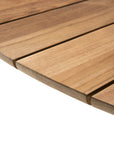 Close-up of the Ethnicraft Circle Outdoor Dining Table, crafted from FSC certified natural teak with evenly spaced horizontal planks, a rounded edge, and a light brown finish that highlights the wood grain.