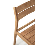 Close-up of the Ethnicraft Jack Outdoor Dining Chair - Teak (without armrest), featuring a minimalist modern design in solid teak with smooth, rounded edges, a natural finish, and visible wood grain on the backrest, seat, and legs.