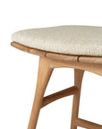 Close-up of the Ethnicraft Osso Outdoor Stool with cushion, featuring smooth, curved wooden legs and a light beige upholstered seat. The craftsmanship and natural wood grain reflect the brands signature outdoor style.