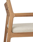 Close-up of the Ethnicraft Jack Outdoor Dining Chair - Teak (with armrest), crafted from solid teak with a light beige upholstered seat. Its clean lines and modern design feature classic European refinement in the partial backrest and armrest.
