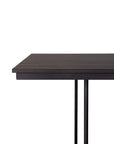 A close-up of the Tacet Dining Table by Ethnicraft shows its dark teak top, thin tabletop, and two black metal legs against a plain white background, highlighting its minimalist design.