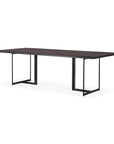 The Ethnicraft Tacet Dining Table is a modern rectangular piece with a dark teak top and black metal sled legs, shown against a white background.