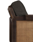 Close-up of the Ethnicraft Panel Lounge Chair in dark brown teak, featuring a dark wooden frame, rattan cane backrest, and thick upholstered cushion—melding classic and contemporary styles.