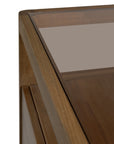 Close-up of the corner of the Ethnicraft Spindle Dresser - Teak, highlighting the FSC-certified teak wood grain and clean edges beneath a smooth glass top.