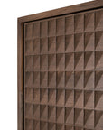 Close-up of the Sono Cupboard by Ethnicraft, showcasing solid teak with hand-carved geometric, pyramid-like textured panels in a rich brown finish and repeating raised squares, each featuring a diagonal facet.