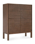 The Sono Cupboard by Ethnicraft is a tall solid teak cabinet with four doors featuring hand-carved geometric panels. Raised on straight legs and finished in rich walnut brown, it showcases expert craftsmanship and unique texture.
