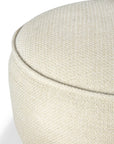 Close-up of the Ethnicraft Donut Outdoor Pouf in Natural, showing its round shape and textured beige upholstery against a white background. Only the top portion is visible, emphasizing the fabric detail and curved design.