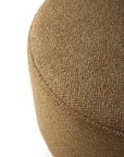 Close-up of the Barrow Pouf - Ginger / Large by Ethnicraft against a white background, featuring textured woven Italian fabric that accentuates its curved edge and top surface.