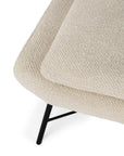 Close-up of the Ethnicraft Barrow Footstool - Off White, showcasing textured cream upholstery and thin, angled black metal legs against a white background.
