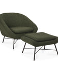 A modern pine green upholstered armchair with the Barrow Footstool - Pine Green by Ethnicraft, both featuring black metal legs and a minimalist, curved vintage-inspired design.
