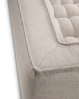 Close-up of the corner of the Ethnicraft N701 2-Seater Sofa in beige, showcasing its tufted cushioning and textured upholstery fabric, and highlighting the sofa’s refined modular design.