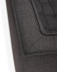 Close-up of the corner of the Ethnicraft N701 2-Seater Sofa in Dark Grey, featuring textured fabric with tufted cushions that highlight its detailed stitching and European-inspired upholstery design.