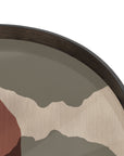 A close-up of the Ethnicraft Overlapping Dots Tray - Round / Large shows its dark wooden rim and abstract beige, gray, and rust pattern inspired by translucent silhouettes, set against a white background.