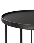 Close-up of the Ethnicraft Round Tray Side Table—a black metal piece with raised edge and slim cylindrical legs from the Tray Collection, offering a minimalist, modern, and customizable design.