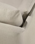 Close-up of a beige fabric sofa corner, highlighting the detailed texture of the linen-blend upholstery and the precise seam lines on the cushion and armrest. The Ethnicraft Weave Sofa | 2 Seater Bone features a removable slipcover that blends style with practicality, making it ideal for contemporary living spaces.