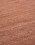 Close-up of the Nomad Kilim Rug - Terracotta by Ethnicraft, featuring a warm, earthy hue and textured woven pattern crafted from sheep wool yarn.