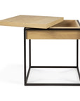 The Monolit Side Table - Oak and Black by Ethnicraft showcases a modern square design with a black metal frame and light oak top that lifts to reveal hidden storage.