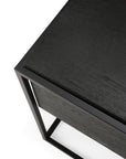 Close-up of the Monolit Nightstand in black oak by Ethnicraft, featuring a sleek metal frame that highlights its minimalist lines and refined European design.