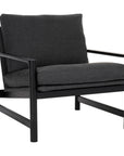 The Troubadour Lounge Chair by Wooden Stories features a solid black oak frame and dark fabric upholstery on the seat and backrest, showcased against a white background.