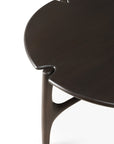A close-up of the Ethnicraft PI Coffee Table - Mahogany, featuring a round design with smooth, curved edges, a distinct notched detail, and sturdy rounded legs.