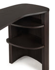 The Ethnicraft Roller Max Desk is a dark wood mahogany piece with a curved corner, two open rounded shelves, and vertical grooved detailing on the sides and front.