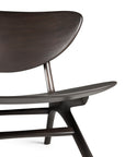 The Ethnicraft Eye Lounge Chair - Mahogany features a curved backrest, angled legs, and a dark, smooth finish. Its minimalist design is inspired by European refinement and is shown here against a white background.