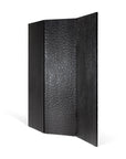 The Ethnicraft Chopped Room Divider features three panels with a textured, hammered surface, handcrafted from black stained mahogany by Javanese artisans, and stands upright in a zigzag fold against a white background.