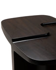 Close-up of the Ethnicraft Brutalist Side Table, showcasing its modern dark finish, smooth rounded edges, and a distinctive groove across the surface.