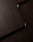 Close-up of two overlapping dark wooden surfaces with rounded corners forms a smooth, modern geometric pattern. The wood grain and subtle sheen highlight the solid mahogany of the Ethnicraft Brutalist Side Table.