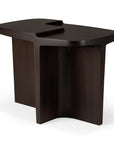 The Ethnicraft Brutalist Side Table features a modern, sculptural solid mahogany base and an asymmetrical top with a recessed groove. Clean lines and a smooth finish subtly reference Brutalist design.