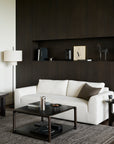 Square Ethnicraft Eda Coffee Table in dark wood with a lower shelf, positioned in front of a white sofa.