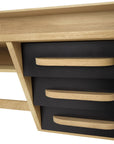 Close-up of the Origami Desk - Black by Ethnicraft, crafted from European oak. It features three black drawers with curved wooden handles, clean lines, and a light wood finish for a modern yet timeless look.