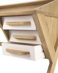 A close-up of the Origami Desk - Cream by Ethnicraft, crafted from European oak with angled legs and three white drawers with wooden handles. The middle drawer is slightly open, showcasing minimalist European elegance.