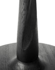 Close-up of the base and lower part of the Ethnicraft Torsion Dining Table - Black Oak, showcasing its smooth, rounded design and textured wood grain against a white background.