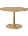 The Torsion Dining Table - Oak by Ethnicraft is a round wooden table featuring a smooth surface, central pedestal, and circular base. Its minimalist, natural oak design highlights refined woodworking techniques.