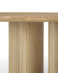Close-up of the Ethnicraft Roller Max Round Dining Table in solid oak, featuring a thick tabletop and vertical slatted cylindrical legs that showcase the natural wood grain against a white background.