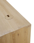 A close-up of the Ethnicraft U Desk - Oak shows its solid oak construction, circular cable management hole with cover, visible wood grain, and clean angular edges.