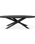 The Ethnicraft Mikado Dining Table Oval in Black Oak features a modern flat top with four angled, intersecting legs forming a sculptural geometric base, shown against a white background.