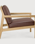 Side view of an Ethnicraft Jack Lounge Chair - Burgundy Leather with a solid oak frame and a burgundy leather seat and backrest.