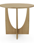 The Geometric Side Table - Oak by Ethnicraft features a flat top, unique intersecting panel base with an arch-shaped cutout, and is crafted from solid European oak in a light wood finish with a minimalist design.